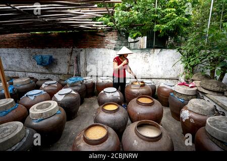 Nghe an Provinz, Vietnam - 31. Juli 2020: Eine Frau arbeitet in einer traditionellen "soy Sauce" Produktionsstätte in Nghe an Provinz, Vietnam. Sojasoße Stockfoto