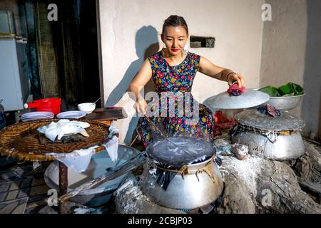 Nghe an Provinz, Vietnam - 2. August 2020: Vietnamesische Frauen machen Reispapier aus Reismehl im Banh trang Handelsdorf, Nghe an Provinz, Vietnam Stockfoto