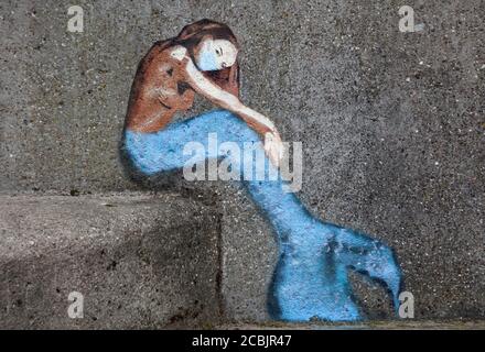 Newhaven Harbour, Edinburgh, Schottland, Großbritannien. 14. August 2020. Temperatur 17 Grad und stark bewölktes Wetter, im Bild: Kunstwerk an der Pier Wand einer Meerjungfrau mit Gesichtsmaske. Stockfoto