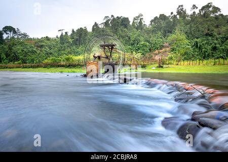 Bambuswasserrad holt Wasser aus dem Bach, um Reisfelder zu bewässern. Besondere Landschaft der Region Nghe an Provinz Berge, Vietnam. Stockfoto