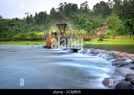 Bambuswasserrad holt Wasser aus dem Bach, um Reisfelder zu bewässern. Besondere Landschaft der Region Nghe an Provinz Berge, Vietnam. Stockfoto