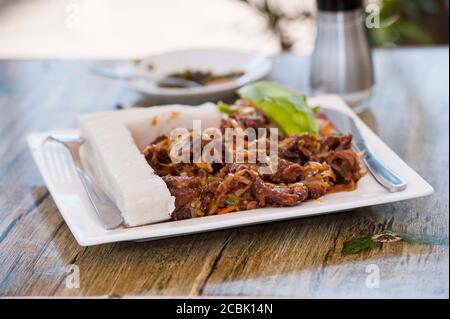 Nsima oder Ugali oder Posho ist eine Hauptmahlzeit für Millionen von Menschen in Afrika südlich der Sahara. Im Volksmund gegessen mit Nyama choma, Ziegenfleisch oder einfach nur Gemüse Stockfoto