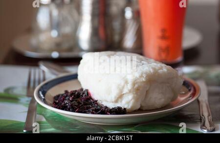 Nsima, auch als Ugali oder Posho bekannt, ist eine Hauptmahlzeit für Millionen von Menschen in Subsahara-Afrika. Es wird hauptsächlich aus Maismehl hergestellt Stockfoto