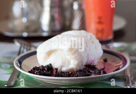 Nsima, auch als Ugali oder Posho bekannt, ist eine Hauptmahlzeit für Millionen von Menschen in Subsahara-Afrika. Es wird hauptsächlich aus Maismehl hergestellt Stockfoto