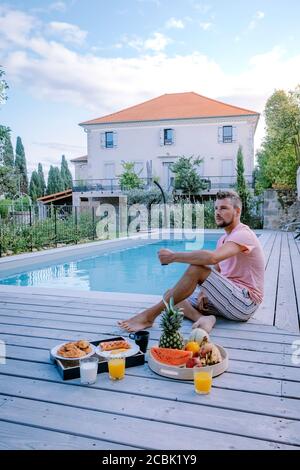 Französisch Ferienhaus mit Holzdeck und Schwimmbad in der Ardeche Frankreich. Kerl entspannen am Pool mit Holzdeck während Luxusurlaub in einem Stockfoto