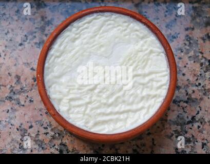 Joghurt im traditionellen griechischen Stil in Keramikglas auf Marmorschreibtisch Stockfoto