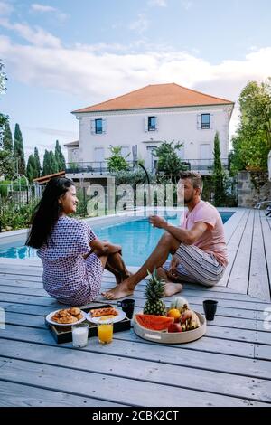 Französisches Ferienhaus mit Holzterrasse und Swimmingpool in der Ardeche Frankreich. Pärchen entspannen sich am Pool mit Holzterrasse während eines Luxusurlaubs Stockfoto