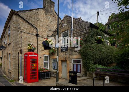 Hayfield Village, High Peak, Derbyshire, gemeinderatsgebäude mit Defibrillator in einer alten roten Telefonbox auf der Market Street Stockfoto