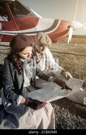 Junges Paar mit Privatflugzeug Blick auf Karte, vertikal Stockfoto