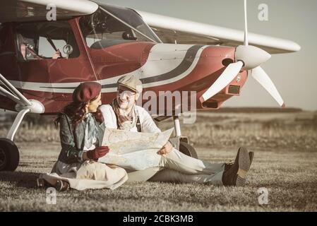 Junges Paar mit Privatflugzeug Blick auf Karte, horizontal Stockfoto