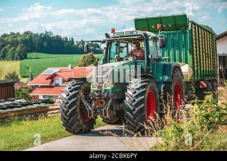 BAYERN - AUGUST 07,2020: Fendt Favorit 926 Vario fährt mit einem Krone ZX400GL Anhänger auf unbefestigten Straßen. Stockfoto