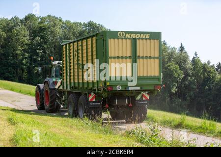 BAYERN - AUGUST 07,2020: Fendt Favorit 926 Vario fährt mit einem Krone ZX400GL Anhänger auf unbefestigten Straßen. Stockfoto