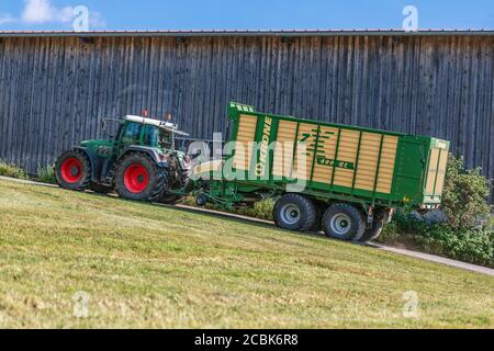 BAYERN - AUGUST 07,2020: Fendt Favorit 926 Vario fährt mit einem Krone ZX400GL Anhänger auf unbefestigten Straßen. Stockfoto