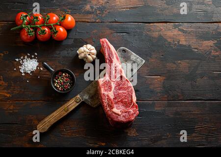 Rohmarktsteak auf Fleischspalter. Bio-Bauernhof marmorierte Prime schwarz angus Rindfleisch. Dunkler Holzhintergrund. Draufsicht. Mit Gewürzen, Pfefferkörnern Stockfoto