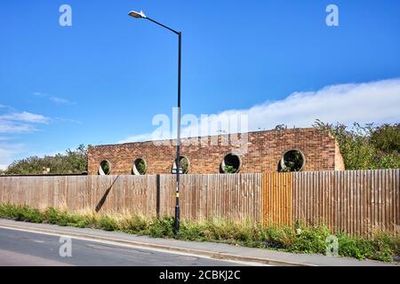 Eine runde Backsteinmauer in der Nähe des Bahnhofs in Rugby, Warwickshire Stockfoto
