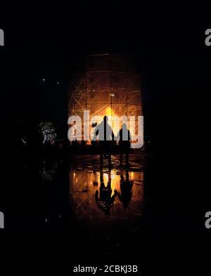 Silhouette von zwei Menschen beobachten Feuer Kunst Installation Large Fire Tornado von Ivo Schoofs beim Lux Helsinki 2020 Light kunstfestival in Kaisaniemenp Stockfoto