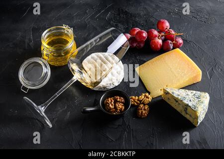 Weißer sauvignon Wein Käse Camembert frische Feigen mit Trauben Honig. Snack auf schwarzem Hintergrund. Seitenansicht Stockfoto