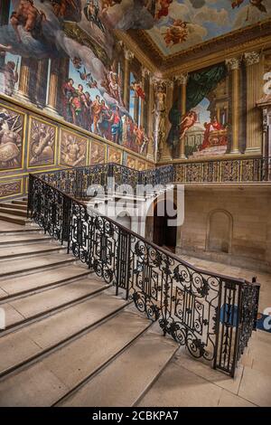 England, Richmond an der Themse. Hampton Court Palace, die Königstreppe mit einer schmiedeeisernen Balustrade und einem Wandgemälde des italienischen Künstlers Ant Stockfoto