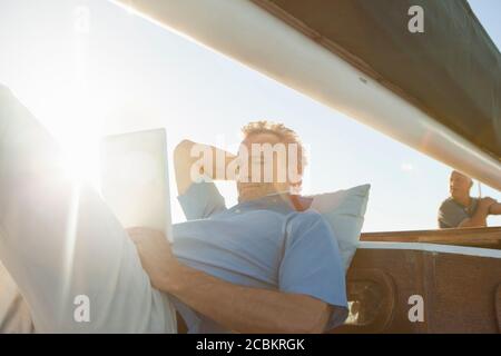 Mann auf Yacht mit digitalem Tablet Stockfoto