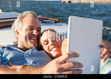 Paar auf Yacht mit digitalem Tablet Stockfoto