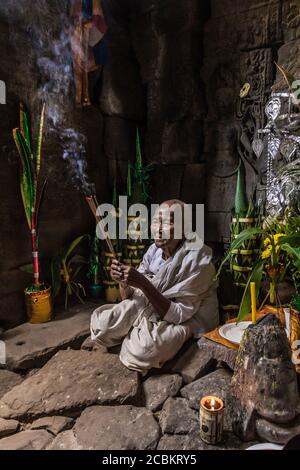 Eifrige Nonne, zündet Weihrauch an und bietet Gebete im Preah Khan Tempel, Angkor, Kambodscha an Stockfoto