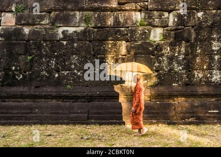 Mönch mit Regenschirm, Bakong Tempel Ruinen (Teil der Roluos Gruppe von Pre-Angkorian Hindu-Tempel), Bakong, Kambodscha Stockfoto