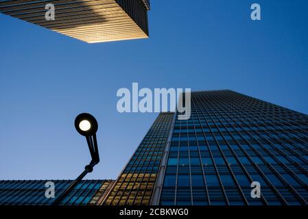 Blick auf Wolkenkratzer und Straßenlaterne in der Abenddämmerung, Canary Wharf, London, Großbritannien Stockfoto