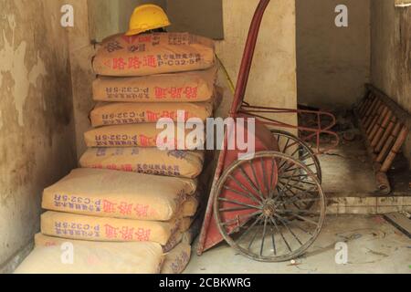 Säcke aus Zement und Schubkarre, Nanfeng Brennofen, Foshan, China Stockfoto