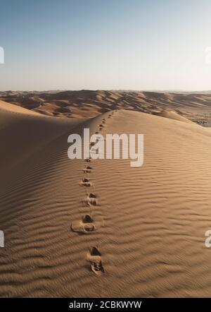 Fußabdrücke auf riesiger Sanddüne in der Wüste des leeren Viertels, zwischen Saudi-Arabien und Abu Dhabi, VAE Stockfoto