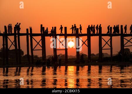 Menschen, die bei Sonnenuntergang über die Bein-Brücke gehen, Amarapura, Mandalay, Myanmar Stockfoto