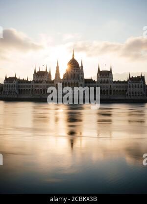 Sonnenaufgang hinter dem ungarischen Parlamentsgebäude & Donau, Budapest, Ungarn Stockfoto