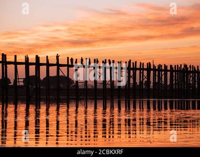 Silhouette der Menschen auf U Bein Brücke bei Sonnenuntergang, Mandalay, Mandalay Region, Myanmar Stockfoto