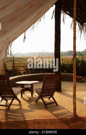 Tisch und Stühle unter dem Dach im Eco Retreat, Goa, Indien Stockfoto