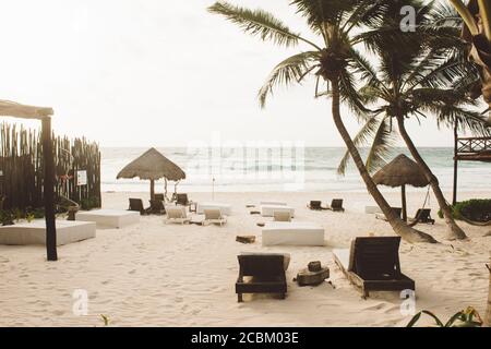 Liegestühle und Sonnenschirme am Strand, Tulum, Mexiko Stockfoto