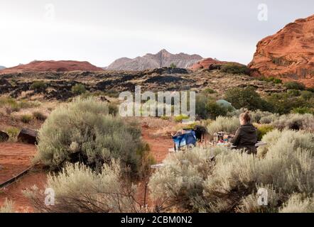 Wanderer bereiten das Abendessen auf der Picknickbank auf dem Campingplatz im Snow Canyon State Park, Utah, USA, vor Stockfoto