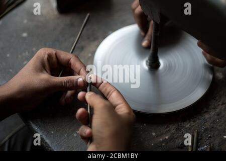 Nahaufnahme der Hände Polieren Rubine in der Werkstatt, Jaipur, Rajasthan, Indien Stockfoto