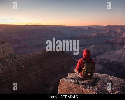 Mann am Südrand des Grand Canyon National Park mit Blick auf den Sonnenuntergang, Arizona, USA Stockfoto