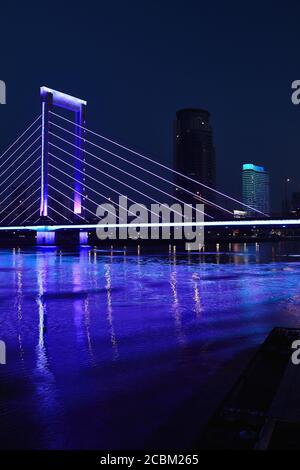 Lila Flutlichtbrücke über Fluss bei Nacht, Ningbo, Zhejiang, China Stockfoto