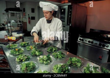 Austin, Texas, USA, 1998: Das hispanische High School Mädchen in weißem Kochhut und Mantel lernt beim Zubereiten von Salaten in der kulinarischen Akademie der Schule Catering-Fähigkeiten. Modellversion ©Bob Daemmrich/ Stockfoto