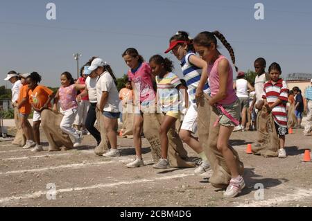 Austin Texas USA, Mai 2006: Mädchen der fünften Klasse treten beim dreibeinigen Sackrennen auf dem Schulhof während des „Leichtathletik-Tages“ an, der traditionell das Frühjahrssemester an vielen öffentlichen Grundschulen in der Region beendet. ©Bob Daemmrich Stockfoto