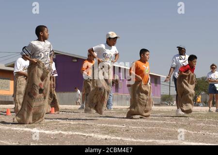 Austin, Texas, USA, Mai 2006. Die Jungen der vierten Klasse nehmen am 40-Yard-Sack-Rennen am „Track & Field Day“ der Grundschule im Raum Austin Teil, der traditionell das Frühjahrssemester an vielen öffentlichen Grundschulen in der Umgebung beendet. ©Bob Daemmrich Stockfoto