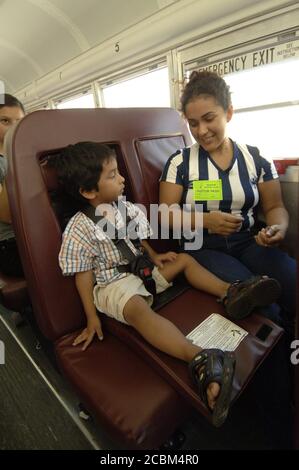 Mabank, Texas, USA, 21. August 2006: Die hispanische Mutter der Mabank Central Elementary School Head Start Student zeigt ihrem 4-jährigen Kind, wie man einen Sicherheitsgurt am Schulbus anschnallt. ©Bob Daemmrich Stockfoto