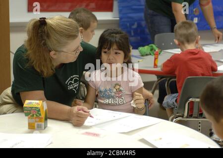 Mabank, Texas, USA, 19. August 2006: Lehrerin tröstet einen verärgerten hispanischen Kindergartner während der ersten Schulwoche an der Mabank Central Elementary School. Stockfoto