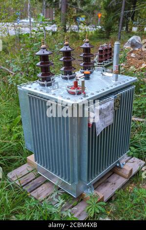 Neuer Transformator für das Stromnetz geliefert und auf dem Boden liegend , warten auf die Installation an Stromleitungen , Finnland Stockfoto