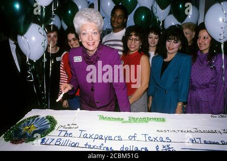 Austin, Texas, USA, 31. Januar 1990: Die Schatzmeisterin von Texas, Ann Richards, schneidet einen festlichen Kuchen, der wie ein Scheck an die Steuerzahler von Texas geschmückt ist. ©Bob Daemmrich Stockfoto