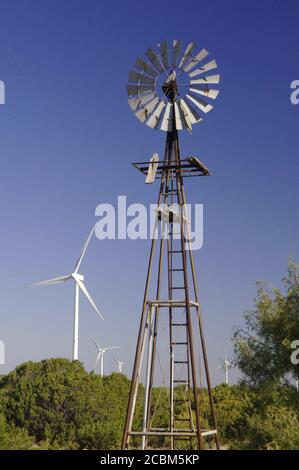 Merkel, Texas USA, 4. Oktober 2006: Eine alte Wasserbrunnen-Windmühle steht vor modernen Windkraftanlagen beim Windkraftprojekt Buffalo Gap in den Grafschaften Taylor und Nolan südlich von Abilene. ©Bob Daemmrich Stockfoto