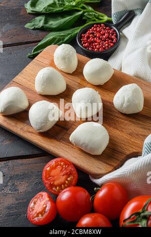 Zutaten Caprese Salat Tomate und Mozzarella mit Basilikum und Kräutern Auf alten Vintage Holz Tisch Bauernhof Bio gestylt Stockfoto