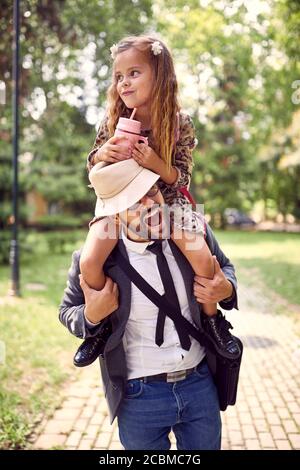 Vater gibt Tochter Huckepack Fahrt in einem Park Stockfoto