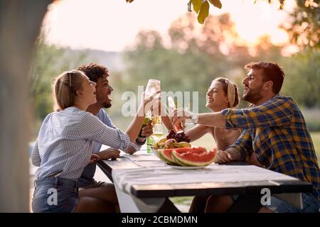 Happy Friends Toasting und Drinks im Freien bei Sonnenuntergang. Stockfoto