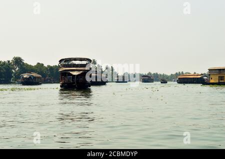 Hausboote festgemacht an der Anlegestelle mit ein paar Hausboote verlassen. Reisen in einem Hausboot in Alleppey ist nicht nur eine Frage der exquisiten Fensteraussichten. Stockfoto